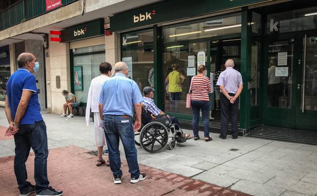 Los clientes hacen cola a las puertas de una sucursal bancaria 