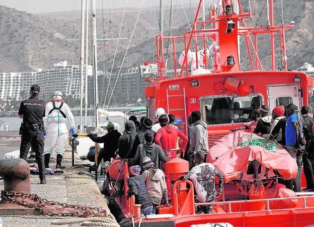 Otra vez, un grupo de inmigrantes tirados en el muelle esperando un centro