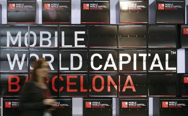 Una mujer pasando ante un anuncio del Mobile World Congress de Barcelona