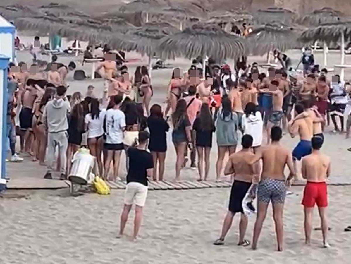 Varios jóvenes protagonizan una pelea con guantes de boxeo en la playa