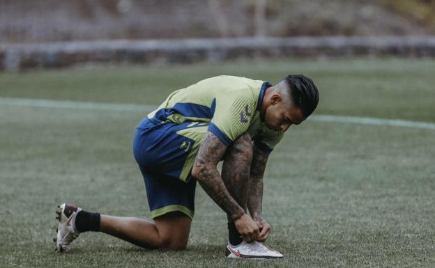 Sergio Araujo, uno de los futbolistas más destacados estas jornadas atrás, se amarra su bota derecha en el césped de Barranco Seco. / UDLP