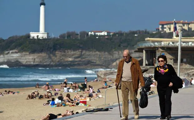 Una pareja de jubilados pasea junto a una playa. /afp