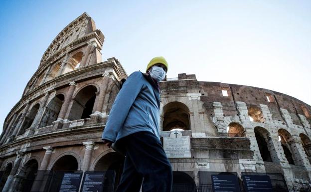 Un turista se protege con una mascarilla en el Coliseo romano. /Efe