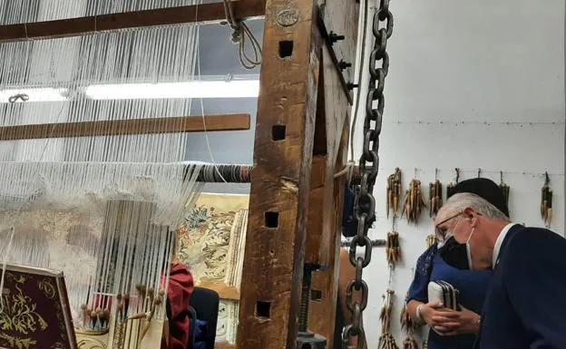 Telar. El consejero Hidalgo observa cómo trabaja una de las viejas máquinas que se exponen en la Real Fábrica. 