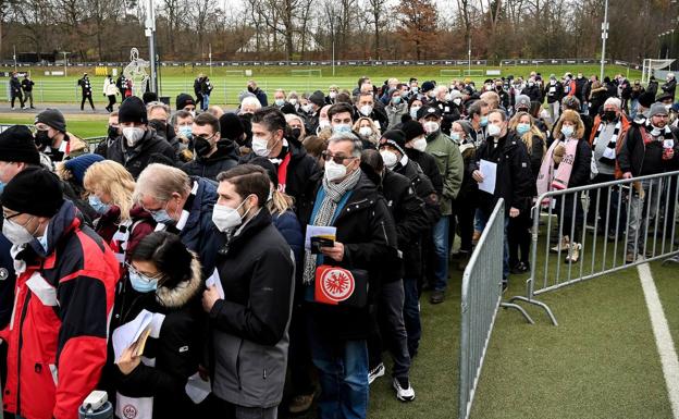Aficionados hacen cola para vacunarse en un centro situado en el exterior de un estadio antes de un partido de la Bundesliga./EFE
