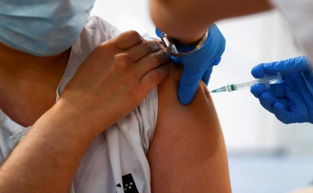 Un sanitario recibe una dosis de la vacuna. 