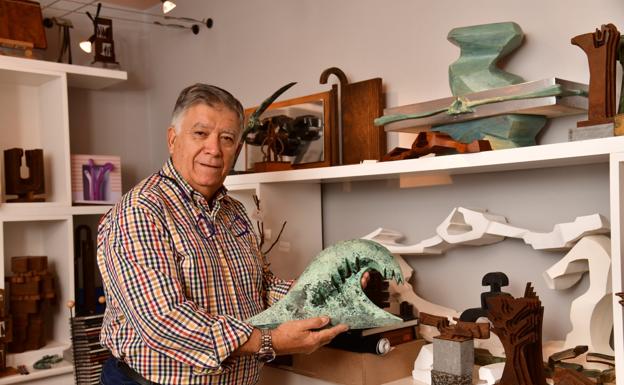 El escultor posa con una de sus obras en su casa de Playa del Hombre.