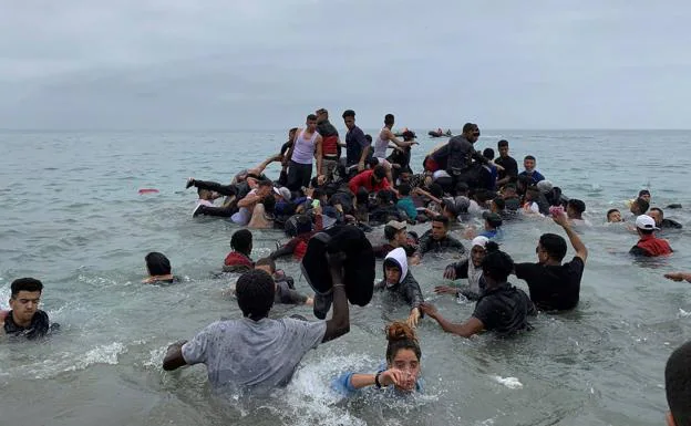 Un grupo de migrantes trata de cruzar el paso. 