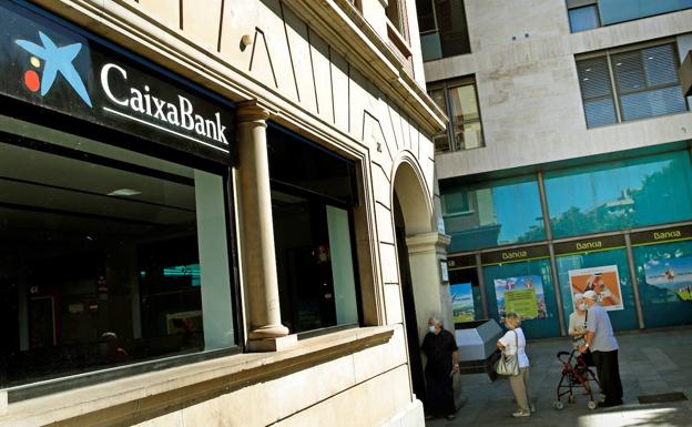 Una oficina de CaixaBank frente a otra sucursal de Bankia antes de la fusión. 
