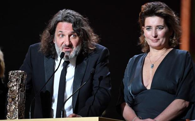 El productor de cine francés Olivier Delbosc y Sidonie Dumas reciben el premio a la Mejor Película por 'Las ilusiones perdidas'./AFP