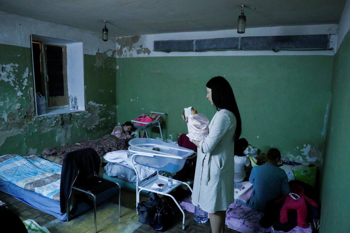Una madre sujeta a su bebé en el sótano de un hospital de Kiev