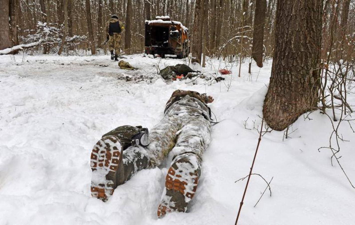 Cadáver de un militar ruso cerca de un vehículo militar destruido en un bosque en las afueras de Kharkiv.