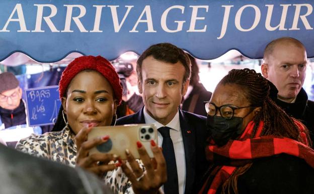 Macron se fotografía con una de sus seguidoras durante una visita al mercado de Neuilly-sur-Seine, cerca de París. /afp