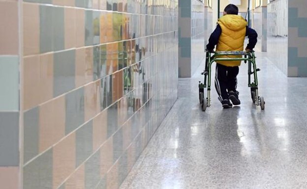 A child with a disability walks down the hall of a school.  /JJU
