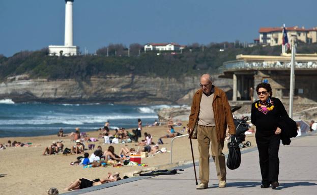 Dos jubilados pasean frente a una playa. /ARCHIVO