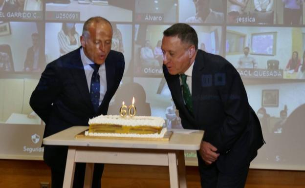 Fernando Berge, president, and Manuel del Castillo, general director of the entity, blow out the candles on the anniversary cake during the act broadcast in streaming for all the entity's offices. 