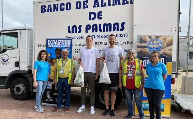 Granca Salvó and Shurna players pose with volunteers from CaixaBank and the Food Bank. 