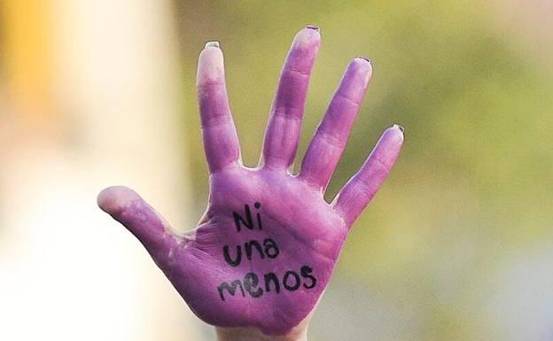 A woman shows the palm of her hand in a demonstration against sexist violence. 
