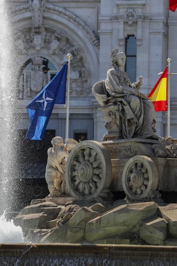 La madrileña Plaza de la Cibeles, junto a banderas de la OTAN y España. 