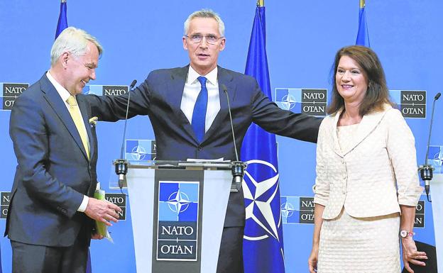 Stoltenberg se dispone a abrazar a los ministros de Exteriores de Finlandia, Pekka Haavisto, y Suecia, Ann Linde, después de la firma del protocolo de ingreso.