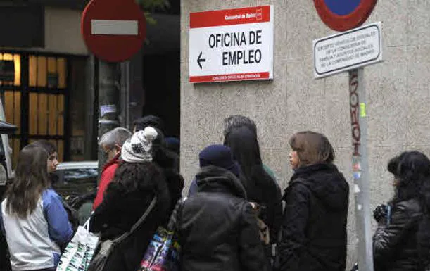 A group of people queue outside an employment office. 