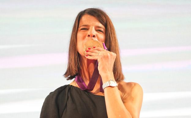 Ruth Beita kisses her bronze metal achieved almost ten years ago. 
