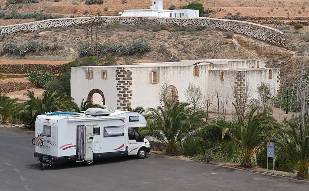 Un parking asfaltado para autocaravanas con vistas al convento de Betancuria
