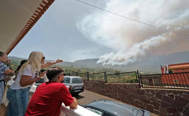 Residents of the neighborhood of Las Llanadas, in the Tenerife municipality of Los Realejos, observe the fire that affects the north of the island. 