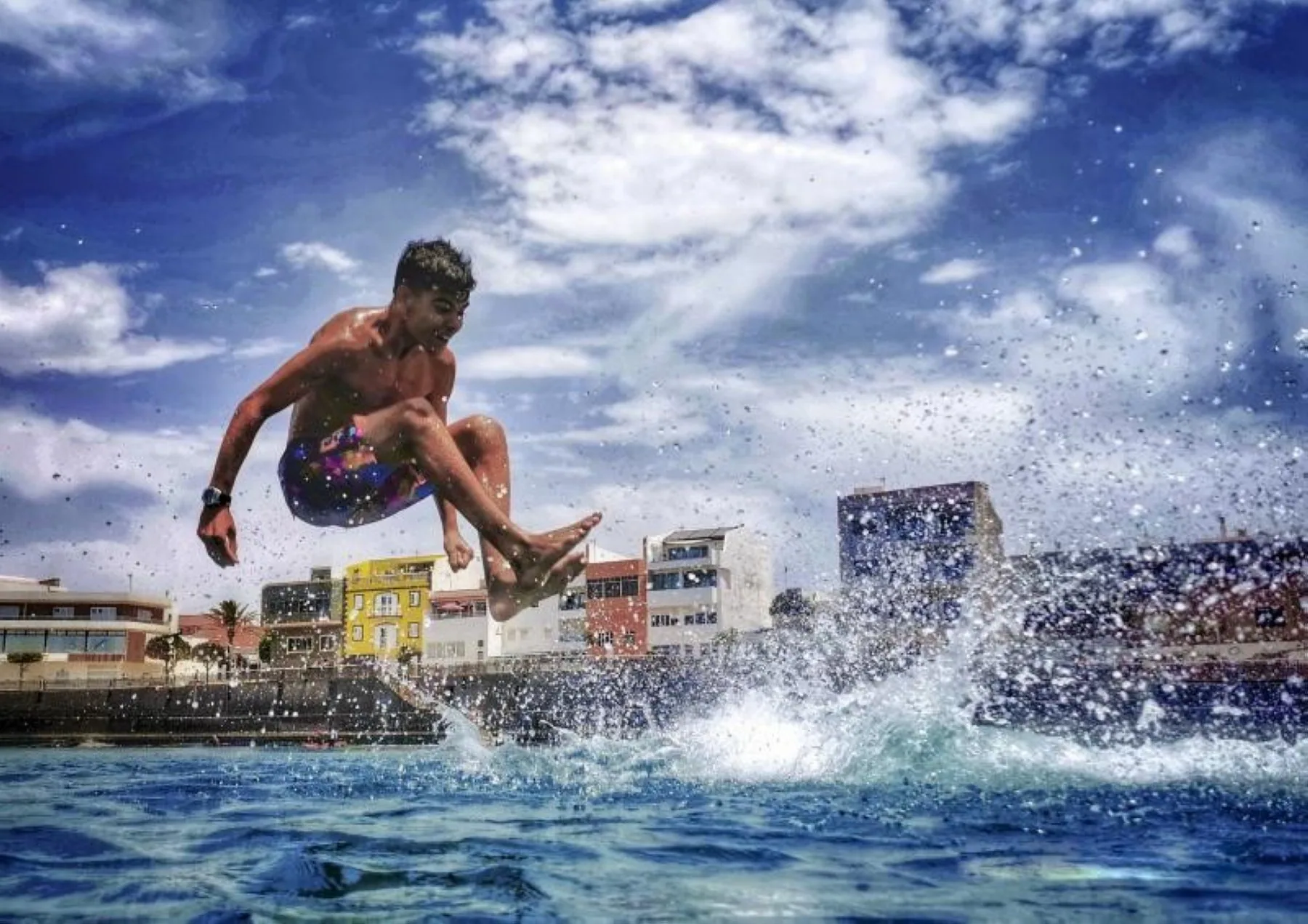 Un joven salta al mar en la playa de Arinaga. / ARCADIO SUÁREZ