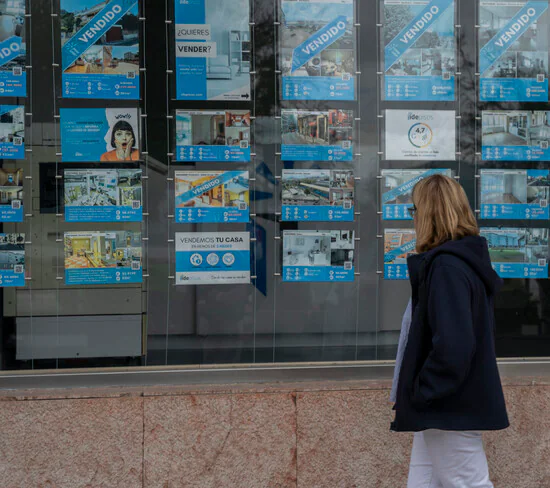 A woman looks at the advertisements of a real estate agency. 