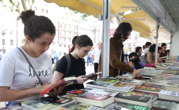 Two young people look at books, one of the products that can be purchased with the cultural voucher. 