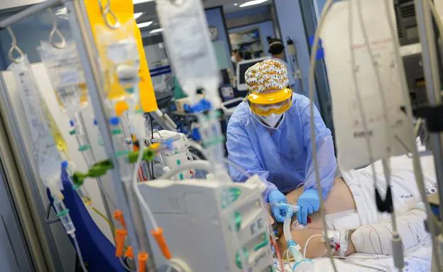 Una sanitaria atiende a un paciente de covid en una unidad de cuidados intensivos (UCI)./R. C.