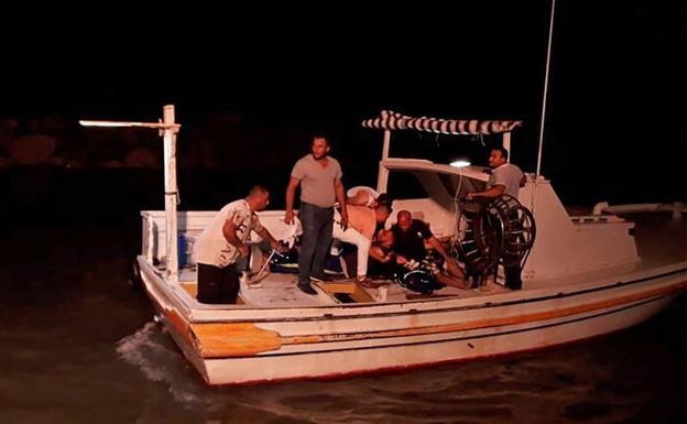 Una embarcación recupera uno de los cadáveres de los migrantes. 