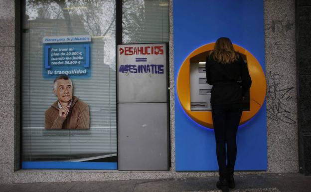 A woman withdraws money from an ATM in Madrid. 