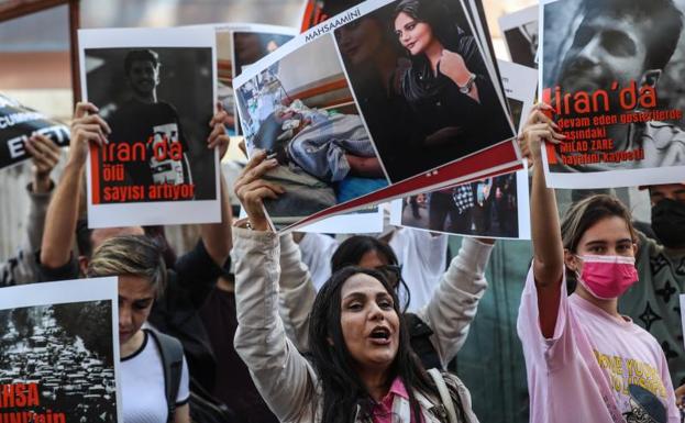 Un grupo de iraníes sostiene fotografías de Mahsa Amini durante una protesta frente al consulado de Irán tras la muerte de Mahsa Amini en Estambul, Turquía. 