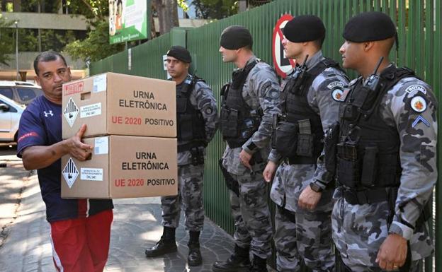 Un empleado electoral traslada urnas electrónicas a un colegio en Brasilia. /AFP