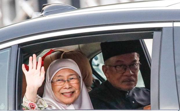 Anwar Ibrahim y su esposa Wan Azizah Wan Ismail abandona el palacio nacional Kuala Lumpur tras la ceremonia de toma de posesión del cargo. /FAZRY ISMAIL / AFP