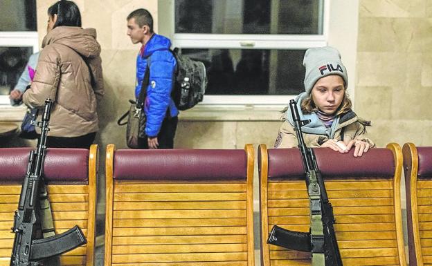 Una niña observa las armas depositadas en una comisaría de la Policía. 