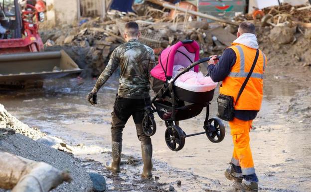 Dos miembros del servicios de rescate cargan un carrito de bebé tras el corrimiento de tierra en la isla italiana de Ischia. 