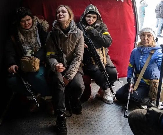 Cuatro mujeres esperan el momento de subirse a un transporte militar para ser trasladadas al frente en Ucrania/
