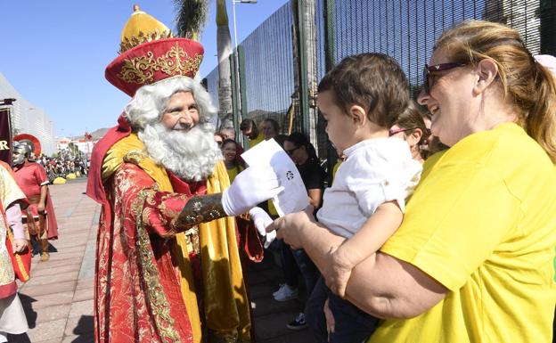 Un niño entrega su carta al rey Melchor. 